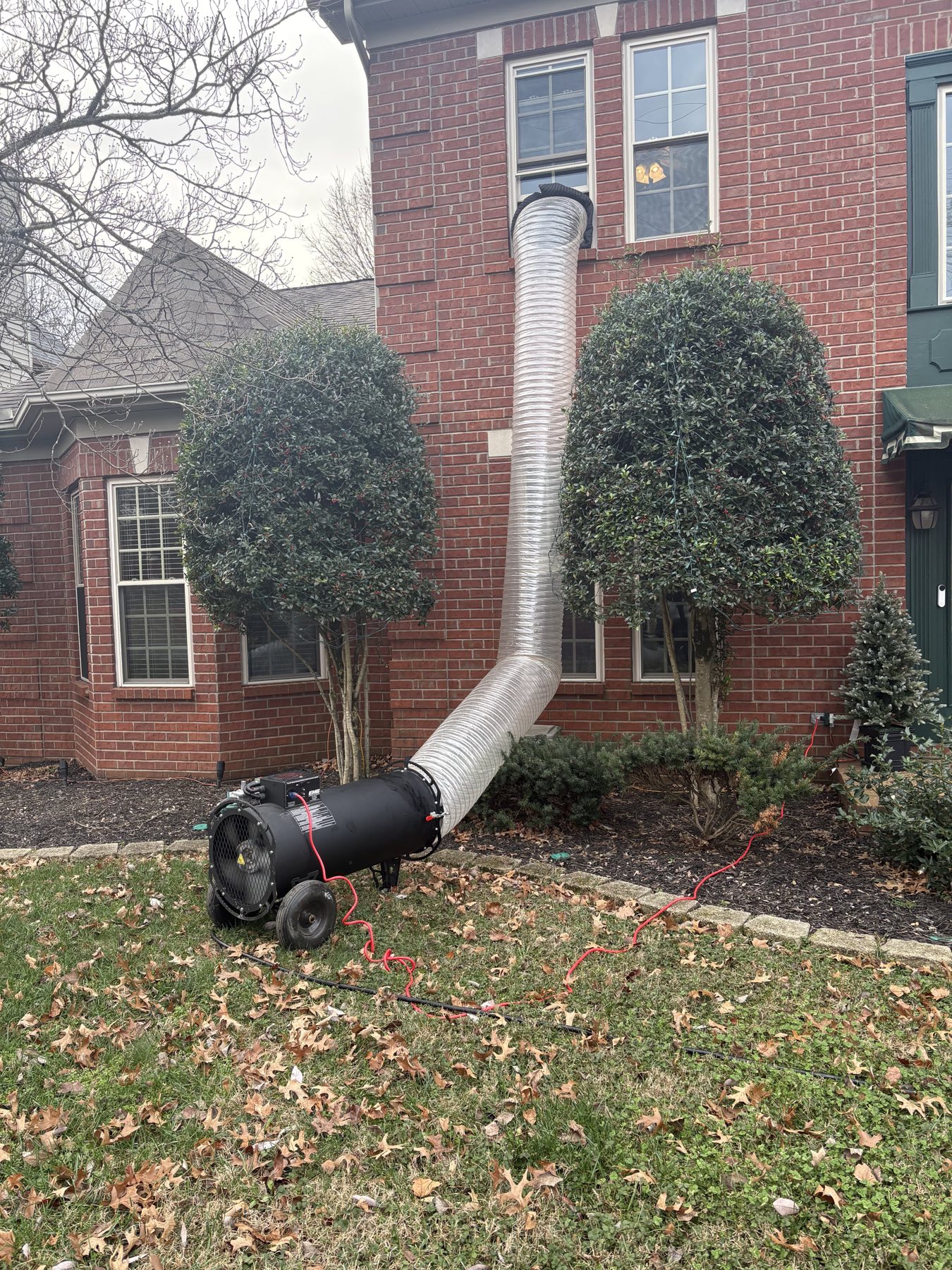 EcoForce heat treatment duct lifted into an upper window of a brick home in Nashville