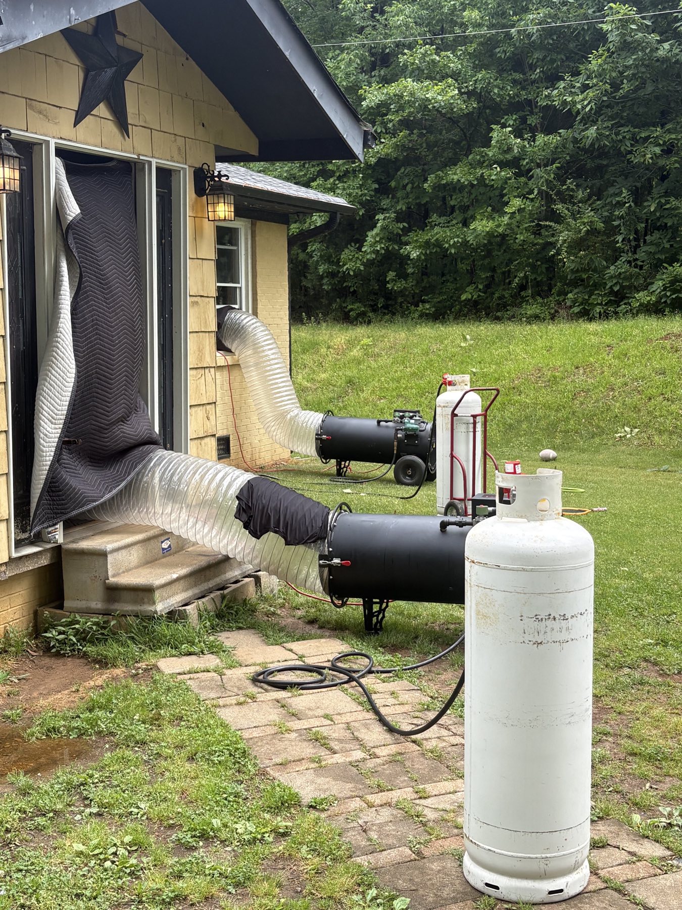 Two EcoForce heat units staged outside a home with propane tanks during an active bed bug heat treatment